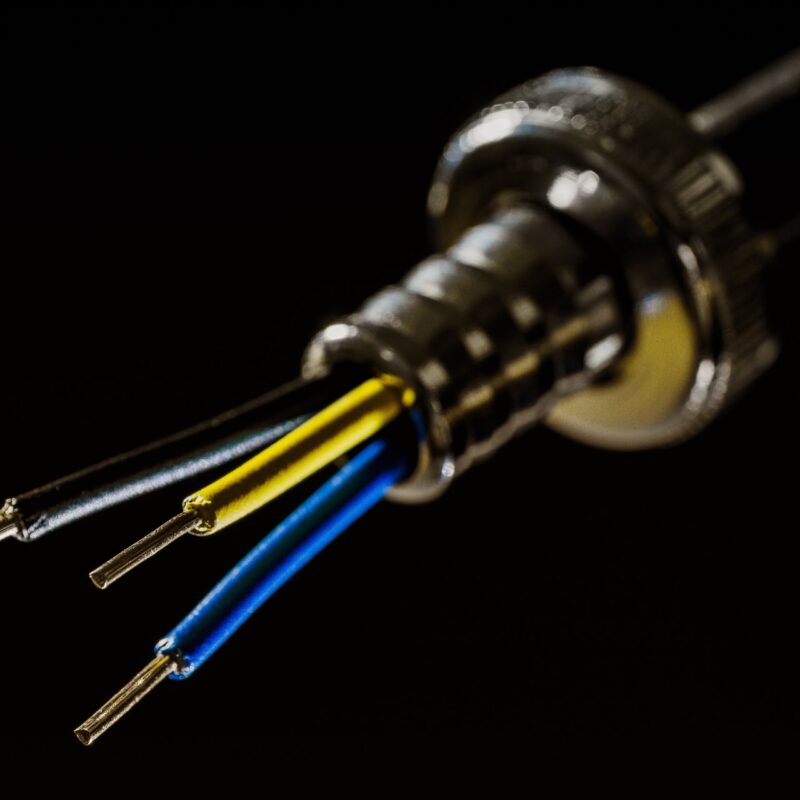A picture showing three wires coming out of a metal tube, some of the work done by electrical contractors